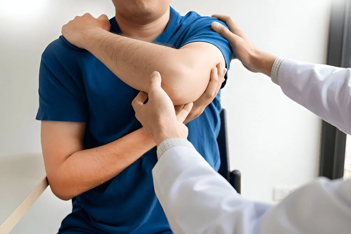 Chiropractor examining from shoulder pain in clinic
