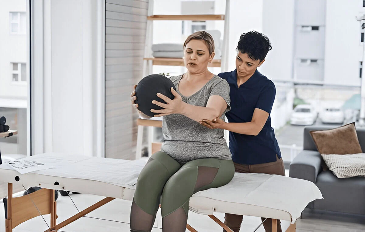 Physiotherapist, woman and medicine ball for exercise, wellness and help in clinic or session
