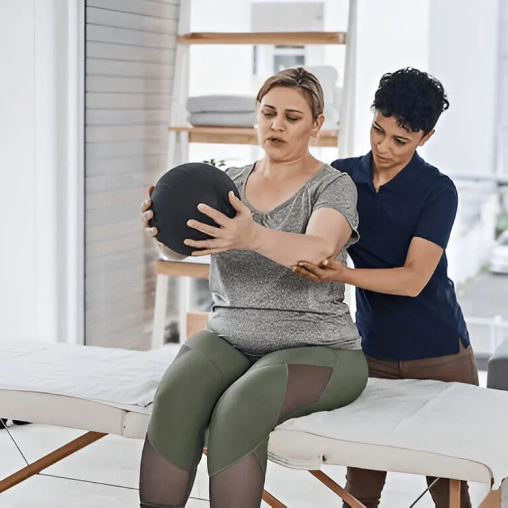 Physiotherapist, woman and medicine ball for exercise, wellness and help in clinic or session